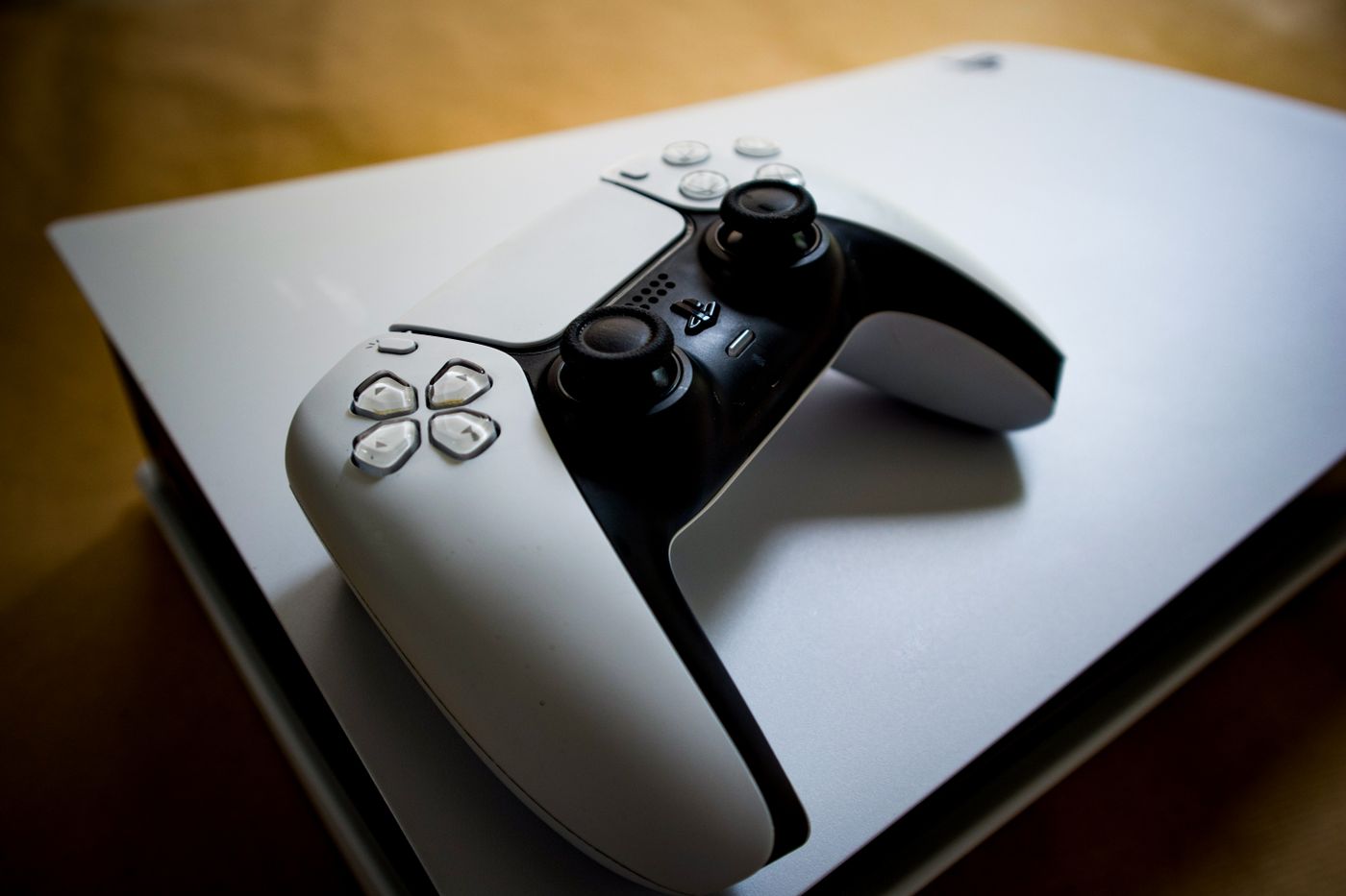 Consola PlayStation 5 con un control DualSense sobre su cubierta.